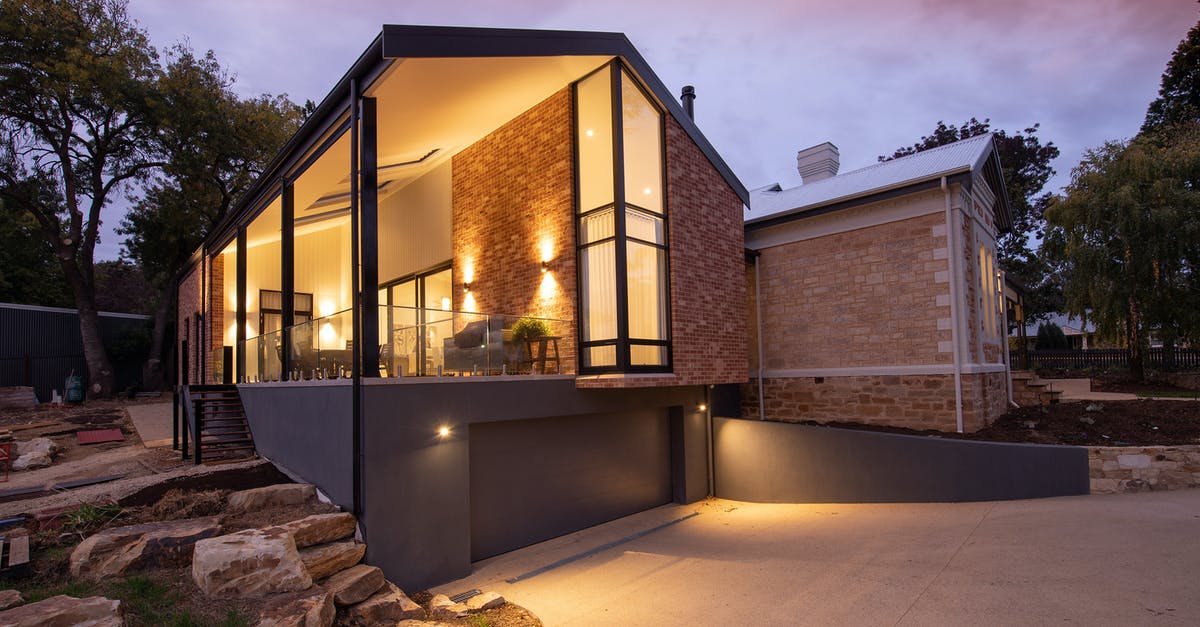 How do I enable Silent Mode? - Contemporary building facade with glowing lamps near walkway at sunset