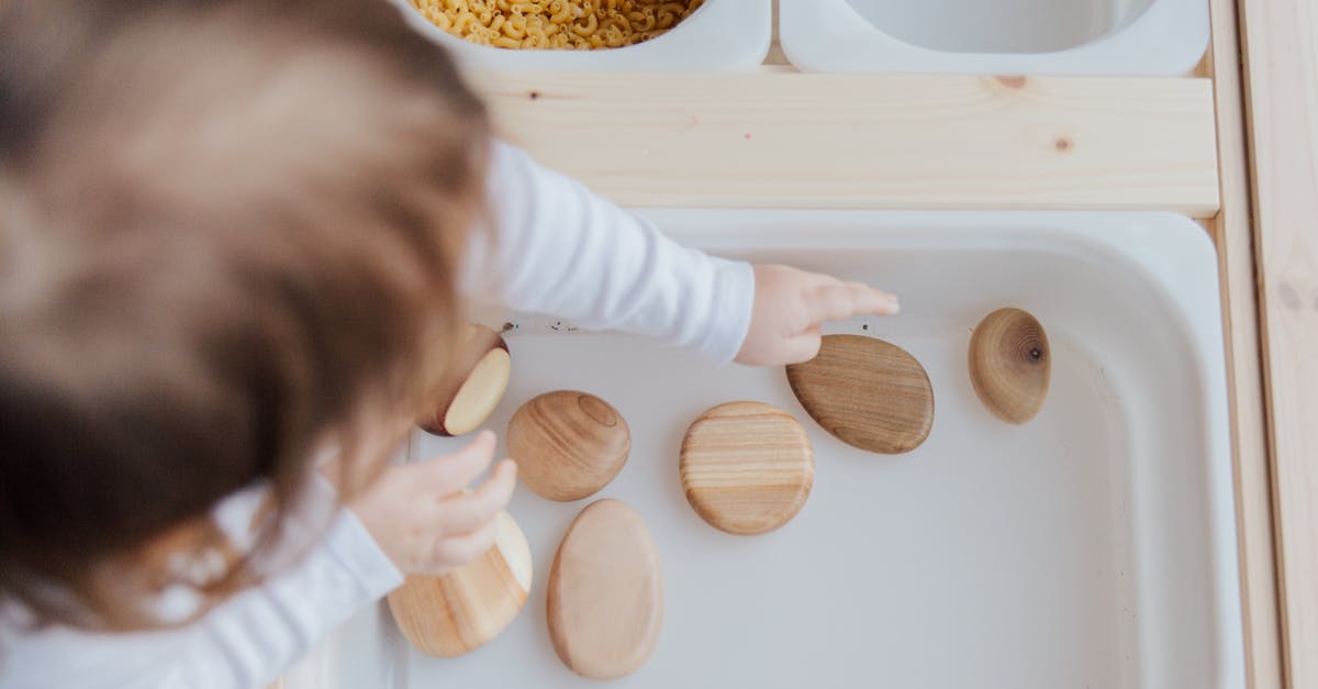 How do I get minecraft capes for free? - Crop anonymous child getting brown stones from white container at home