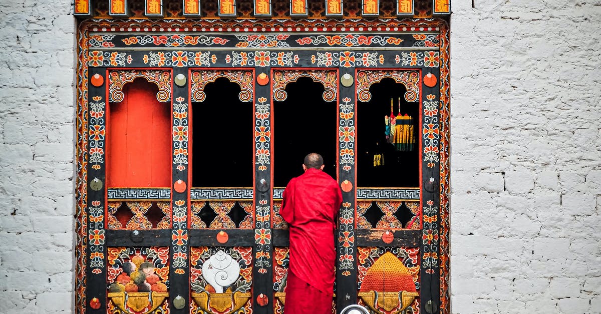 How do I get my building back? - Man in Red Thobe Standing in Front of Red and White Floral Door