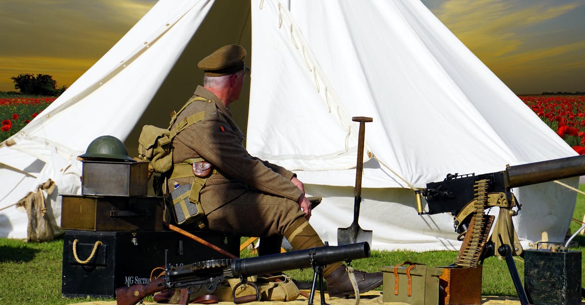 How do I individually load a bullet into a gun? - Man Sitting on Chair Near White Tent