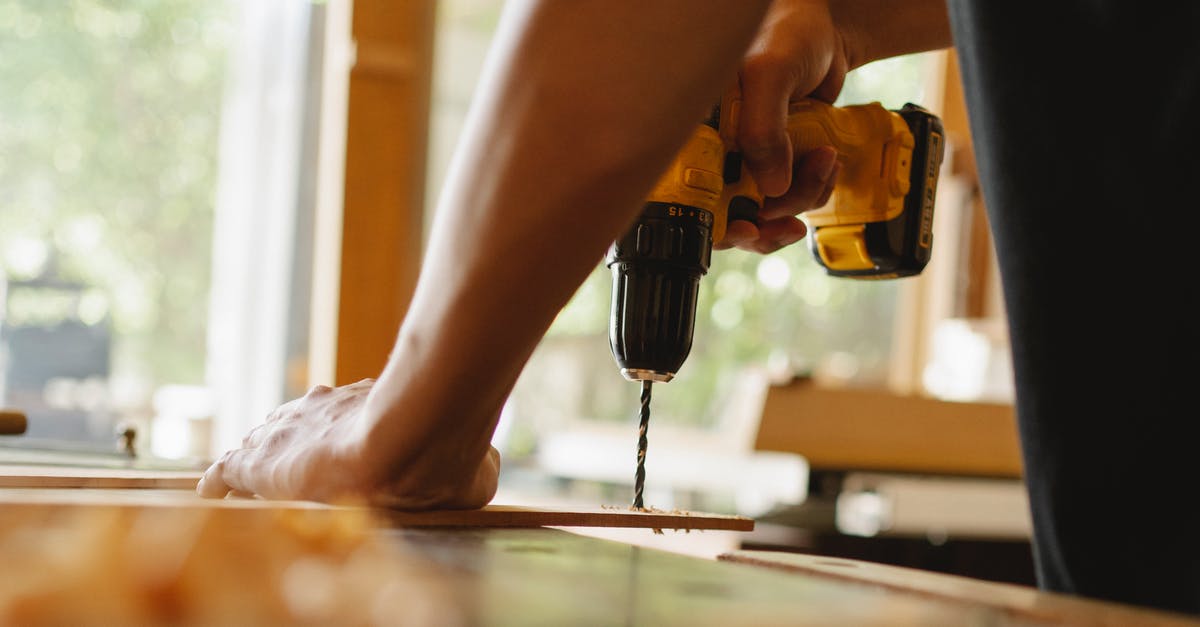 How do I install Gurubani Kaur? - Man drilling wooden plank on desk