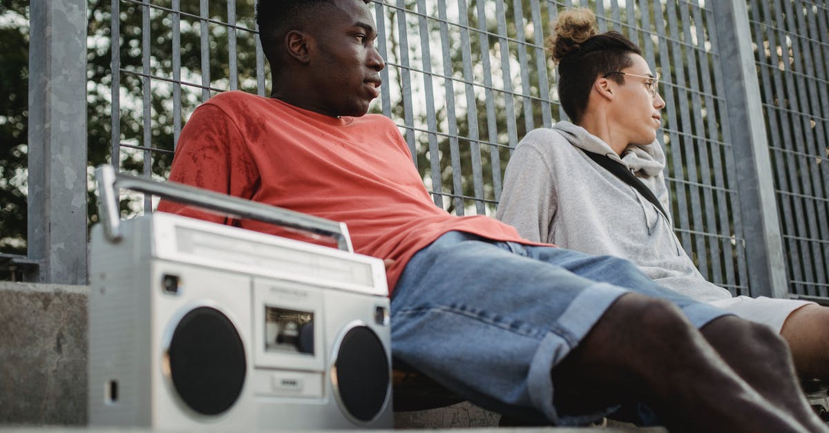 How do I keep my fences from breaking? - Diverse friends with boombox resting near fence in park