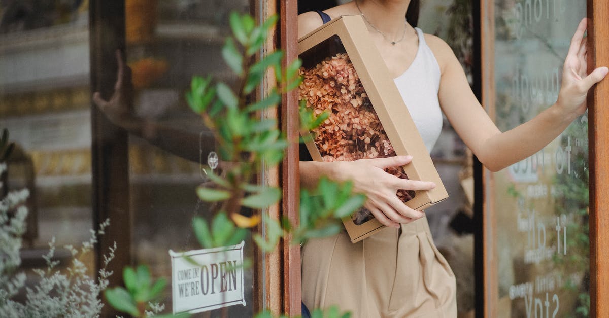 How do I leave a clan - Crop glad woman with dried flowers box leaving floristry store