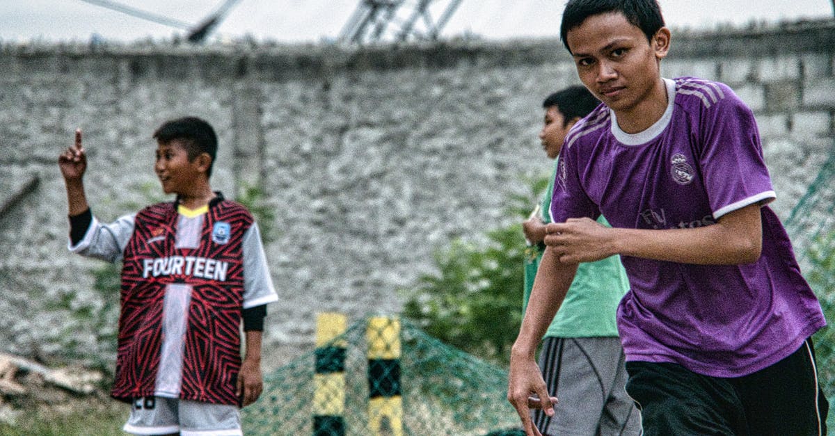 How do I move from settlement to settlement to another? - Ethnic boys playing football on street