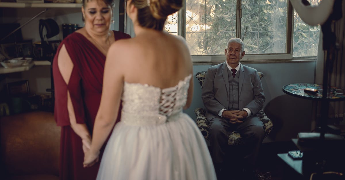 How do I move my family to Windhelm? [duplicate] - Woman in White Tube Dress Standing Beside Man in Gray Suit