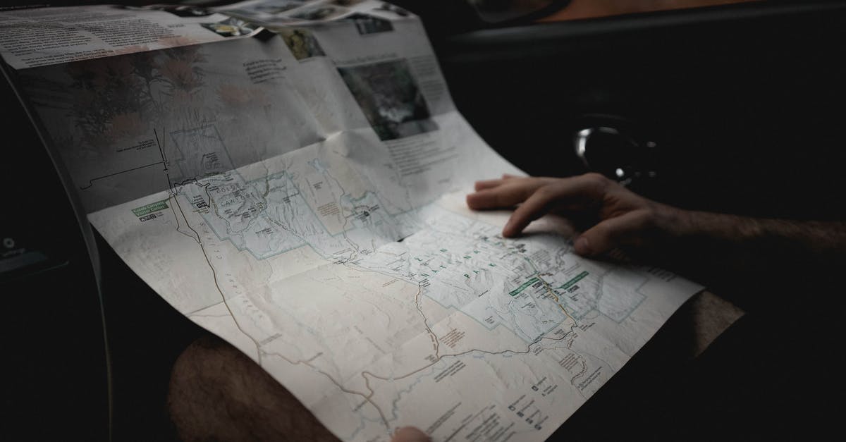 How do I navigate the lost woods? - Crop man with map in automobile