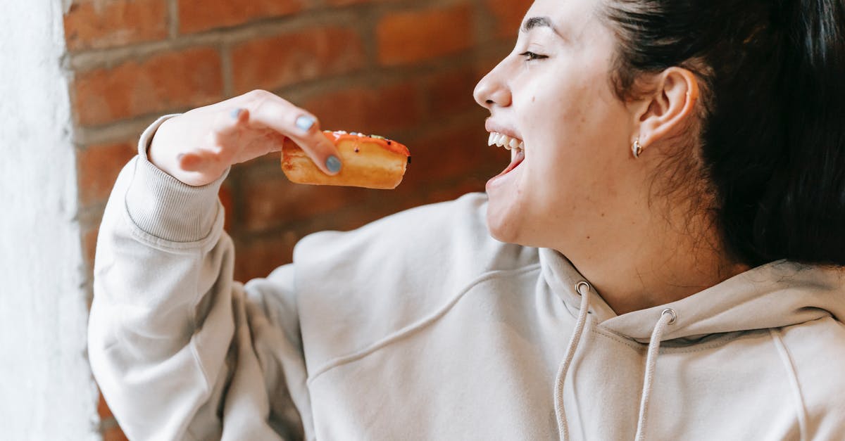 How do I open the new dreamy content in Candy Crush? - Crop excited woman eating fresh yummy donut