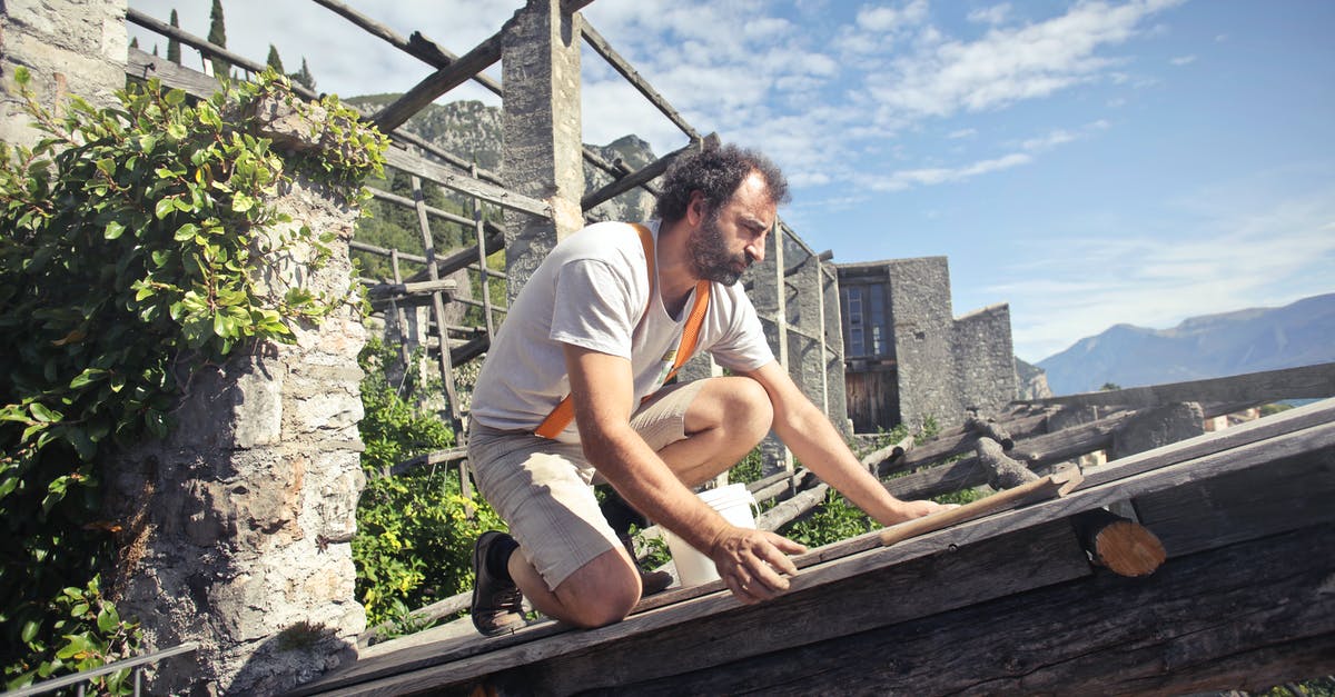 How do I restore Inee to sanity? - Focused man building roof of wooden construction