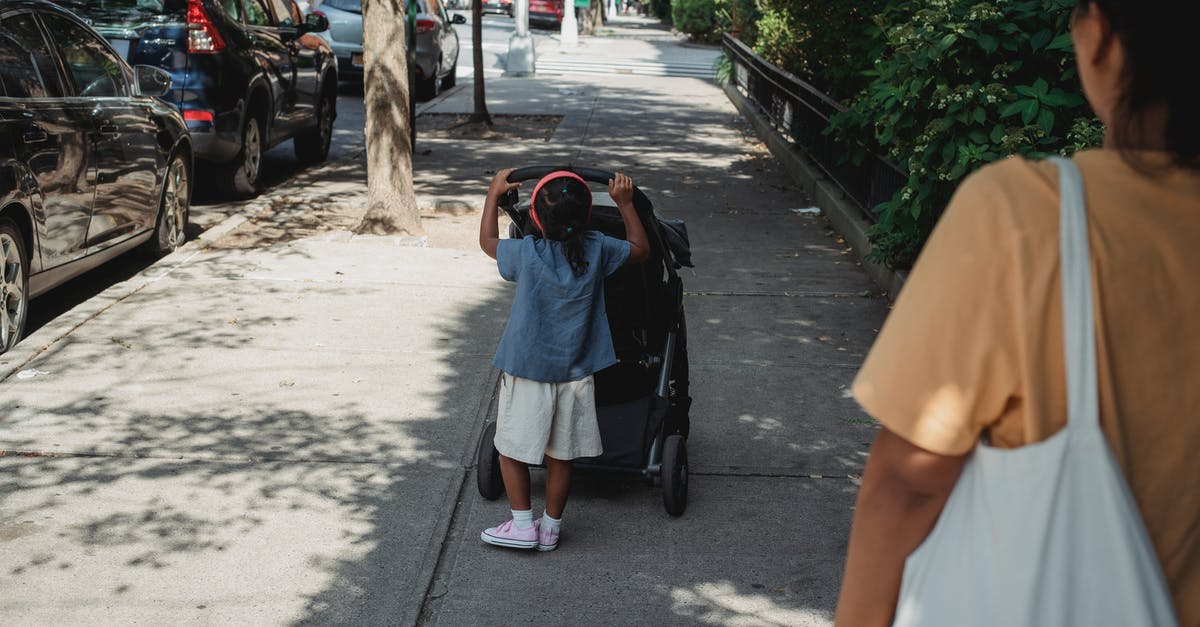 How do I roll back versions? - Unrecognizable ethnic girl pushing carriage on walkway