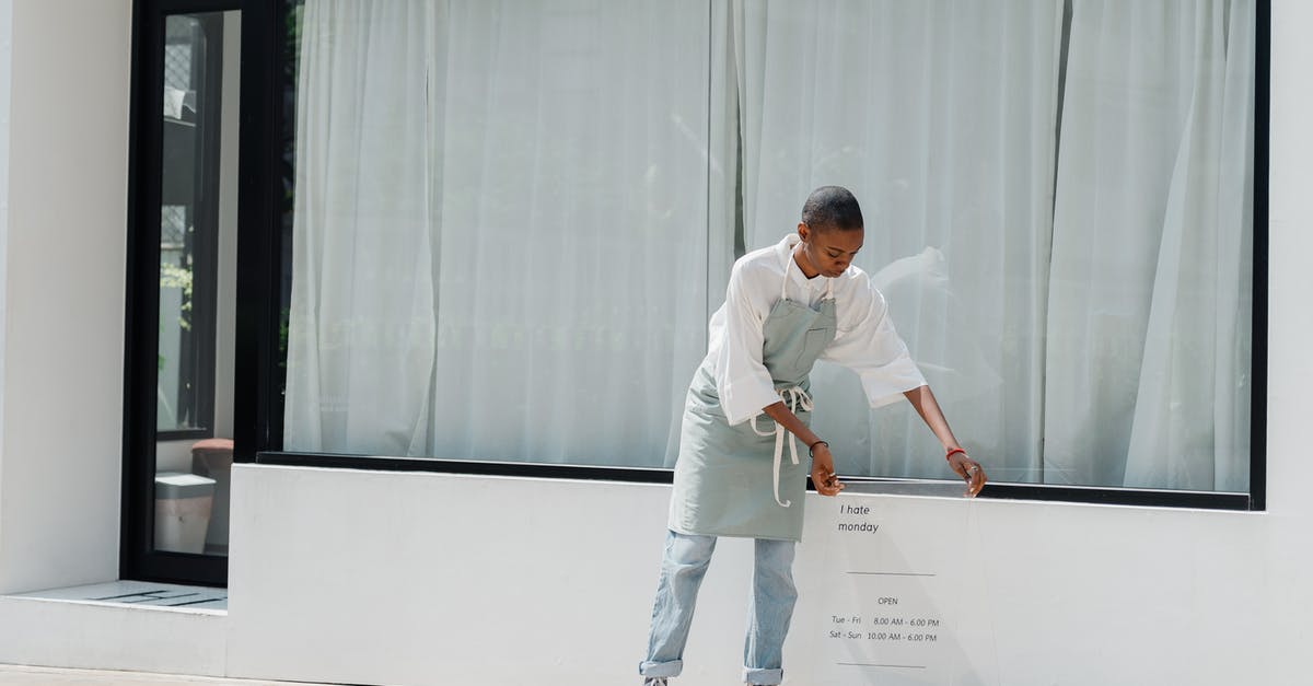 How do I set launcher badges? - Diligent black female worker setting signboard outside cafeteria at sunny day