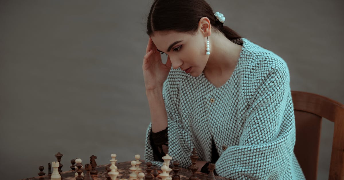 How do I solve level 41? - Concentrated ethnic female sitting on chair and touching head while playing chess against blurred gray background