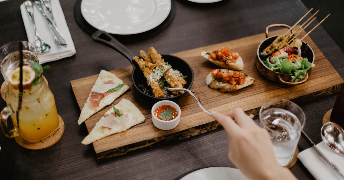 How do you divide the Muzzarella pizza into 7 parts? - Crop woman eating delicious diverse meal in restaurant