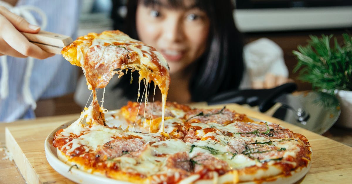 How do you divide the Muzzarella pizza into 7 parts? - Women taking piece of pizza with tomatoes and cheese