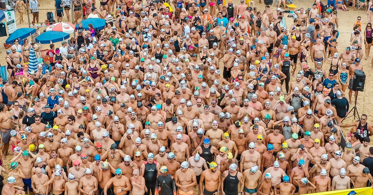 How do you do the jump start in Beach Buggy Racing? - From above people in swimsuits standing together behind line tape ready to start swim marathon on seashore