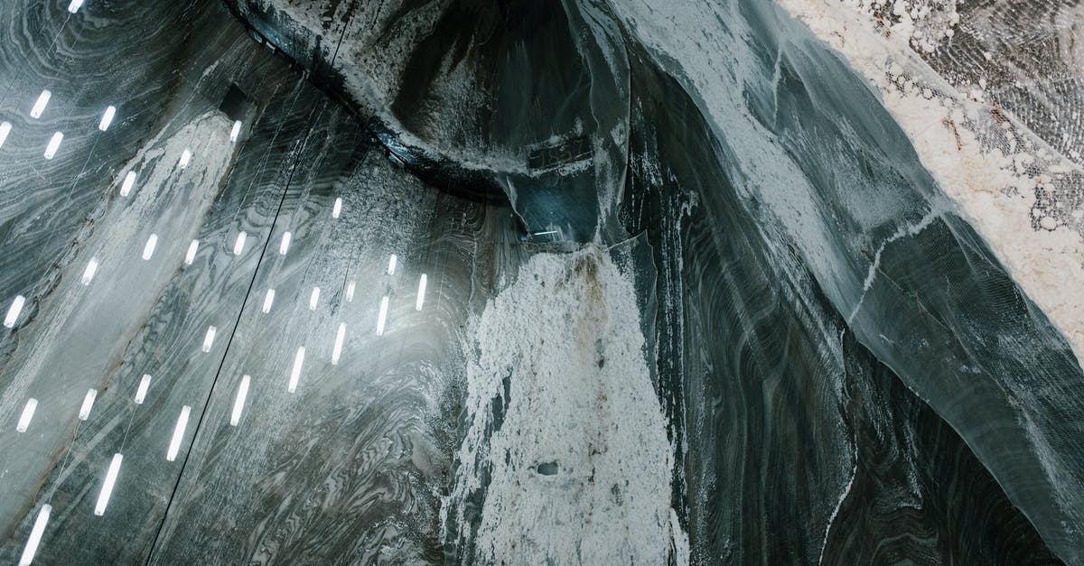 How do you get miners to mine for gems? - From above of hanging LED lamps and salty stalactites on uneven walls of Salina Turda mine in Romania