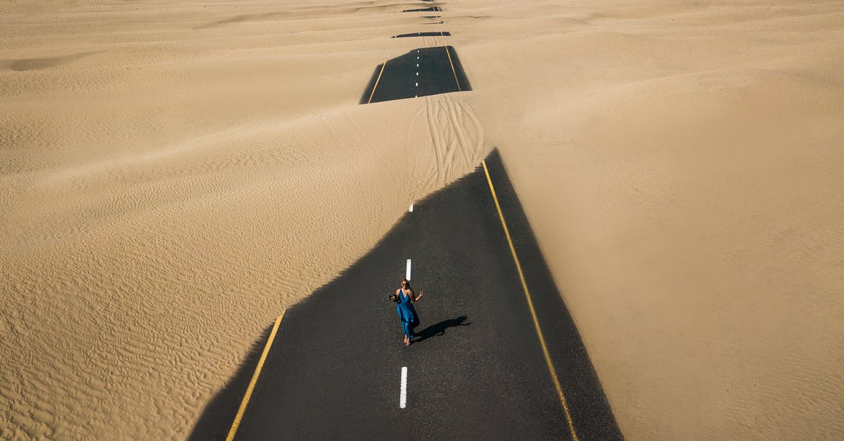 How do you throw your drone without going on cams? - Bird's Eye View Photography of Road in the Middle of Desert