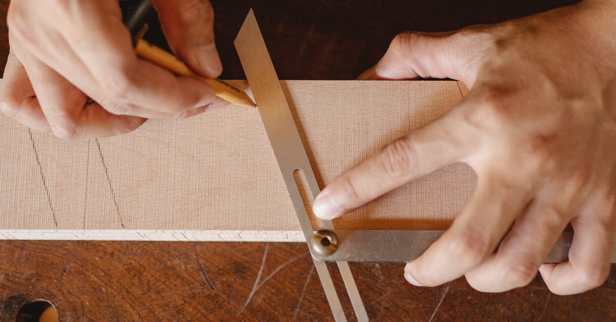 How does marking work in MGS 5? - Top view of crop anonymous woodworker drawing diagonal line on wooden block using bevel on workbench