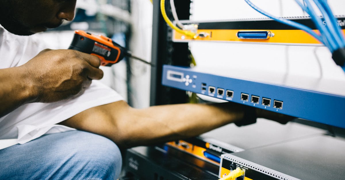 How does the first Control Point in Maintenance work? - Side view crop concentrate African American male mechanic in jeans and white shirt using screw gun while working with hardware