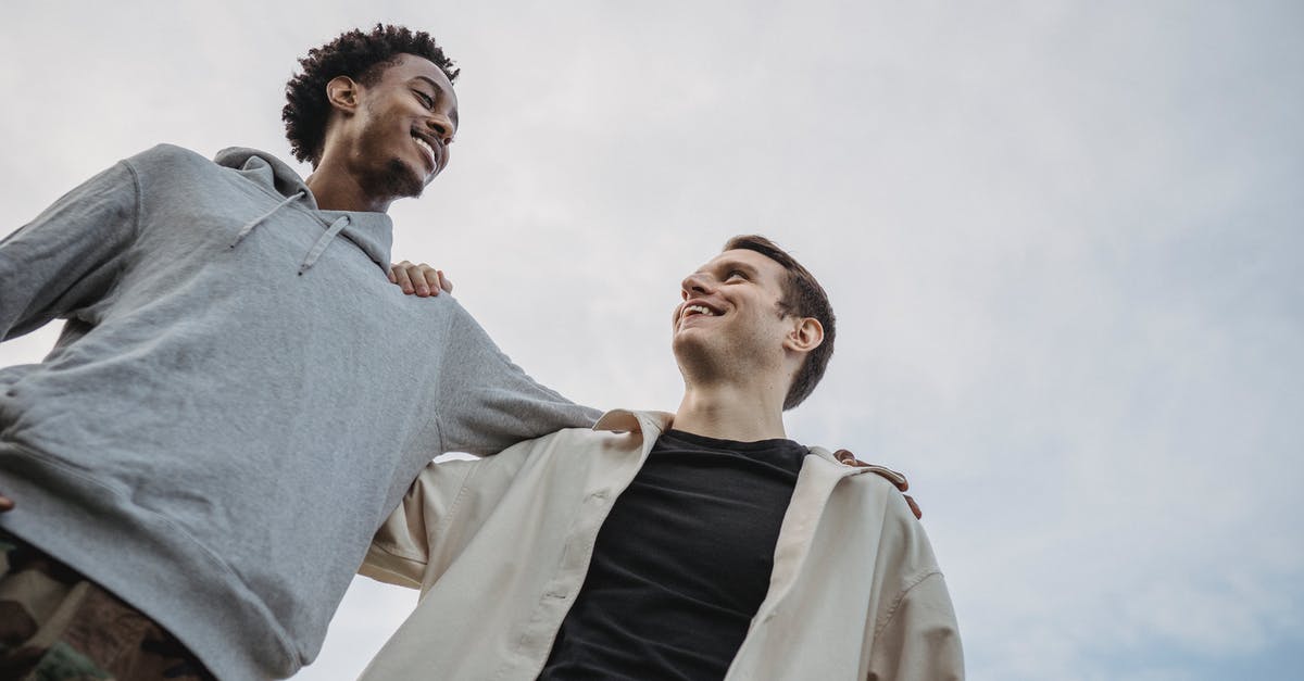 How does the passive item Unity add damage from your other guns? - Happy young multiethnic male friends side hugging against cloudy sky