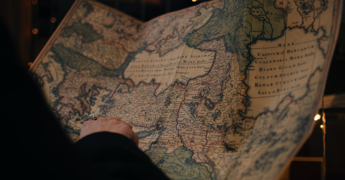 How large is the map in LOTRO? - From behind anonymous person examining antique world map printed on large paper in blue colors in dark room