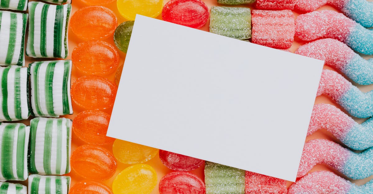 How likely is it to pull a character from data cards? - Closeup from above of white paper card composed on rows of delicious caramel gummy jelly sweets in modern candy shop