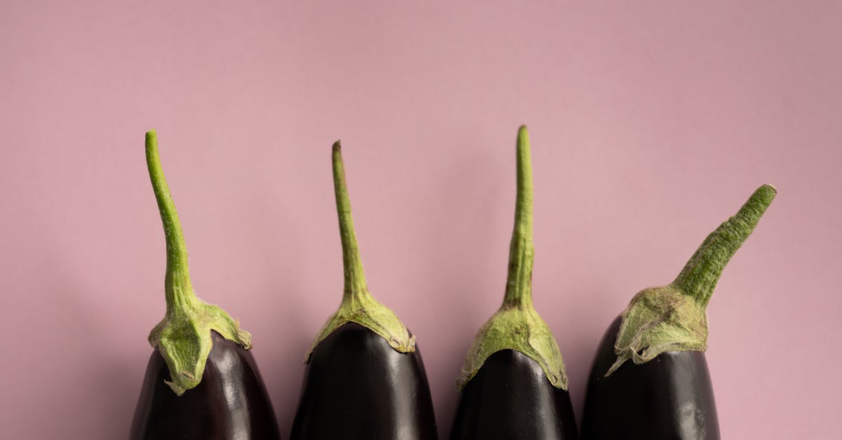 How many difficulty modes does Dark Souls 1 have? - Top view of ripe dark eggplants with green stem placed in row on lilac background