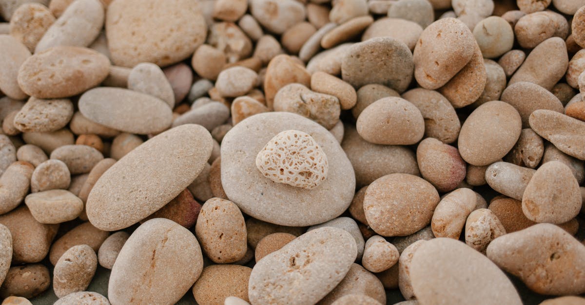 How many mundus stones per zone? - From above of textured background of small stones with blots on surface on shore