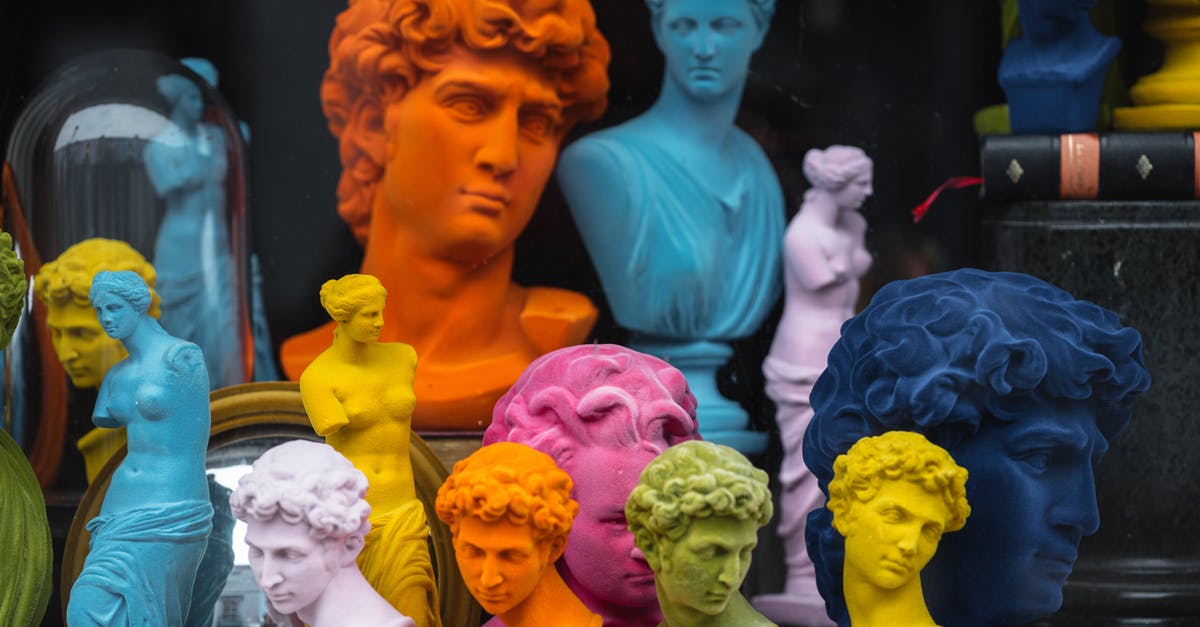 How Many Passengers? - Multicolored head sculptures of David near bright statuettes placed in store with abundance of souvenirs and black pillar with book