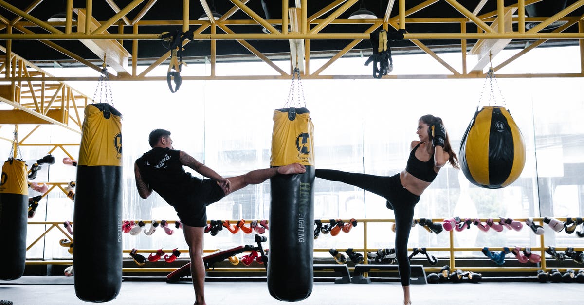 How much fullness does combat drain? - Fit young male and female athletes training on punching bag in gym