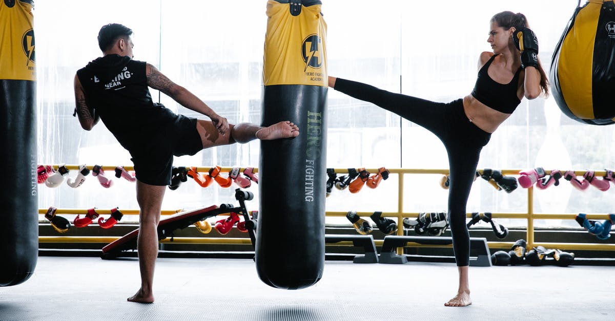 How much fullness does combat drain? - Fit man and woman practicing kickboxing in gym