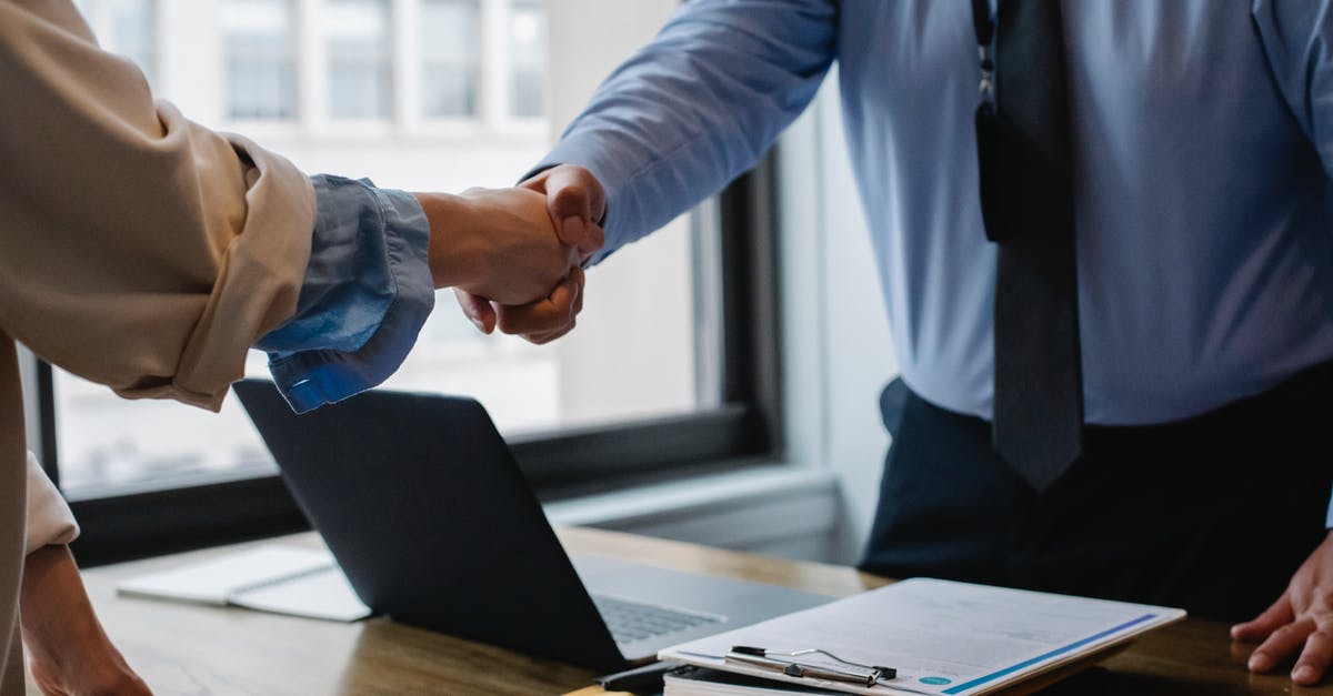 How to achieve reentry with bigger crafts? - Crop unrecognizable coworkers in formal wear standing at table with laptop and documents while greeting each other before meeting