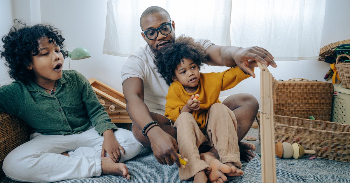 How to create a detailed map of Pokémon 4th Generation Games? - African American man in casual wear and eyewear sitting on floor and playing with kids with curly hair