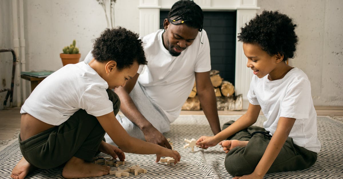 How to create a detailed map of Pokémon 4th Generation Games? - Happy young African American father in casual outfit smiling while sitting on floor and playing with wooden toys with positive twin sons during weekend at home