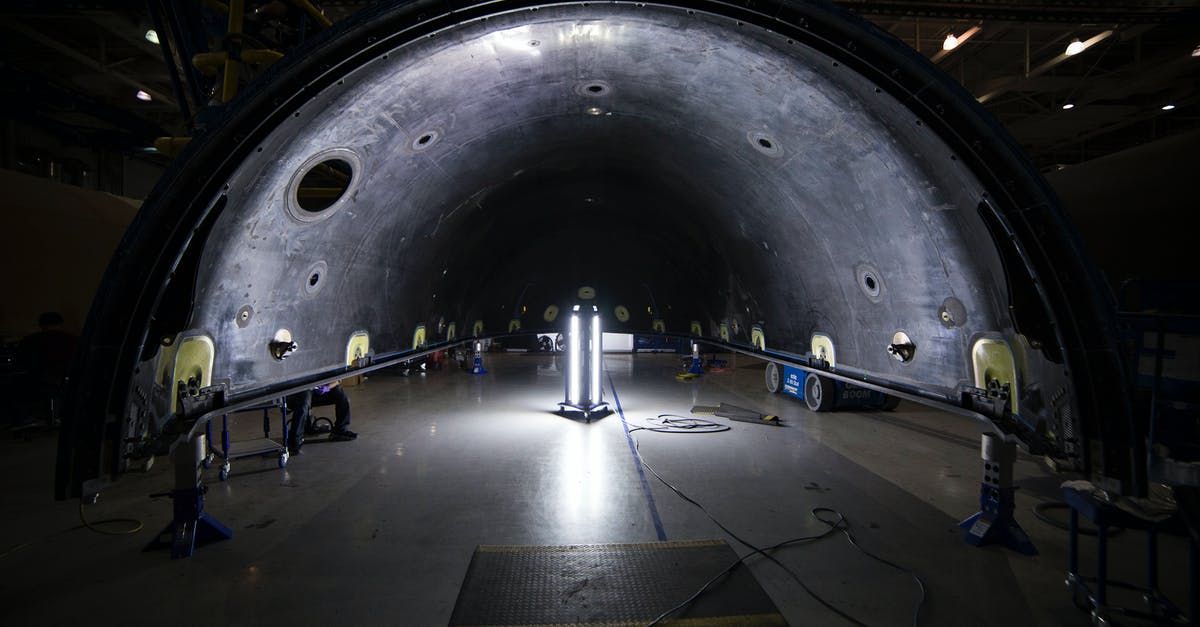 How to design heavy lifter rocket - Illuminated tunnel with rocket construction equipment and lights in dark contemporary spacious industrial factory