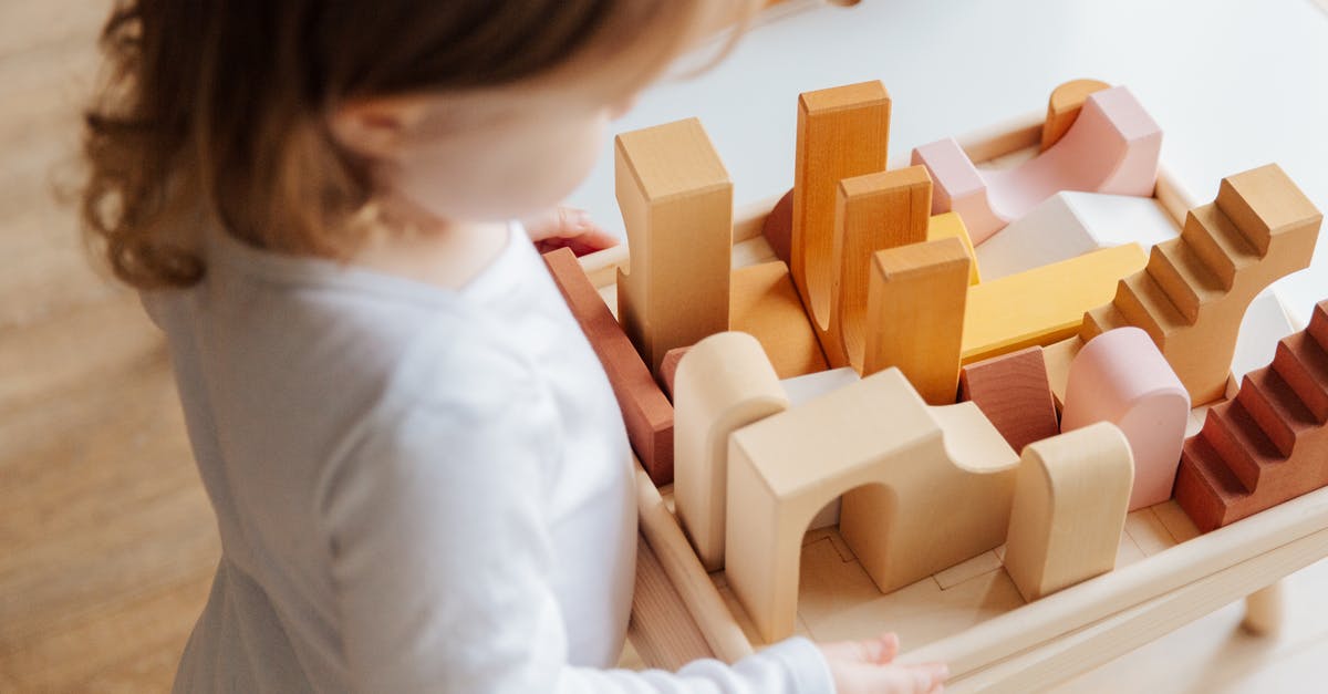 How to fill a block with an Armor Stand - Unrecognizable little girl playing with wooden blocks at table at home