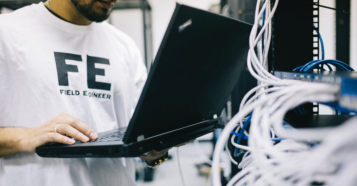 How to fix "key already in use" for Trackmania² Canyon? - Crop focused Asian engineer in white shirt using modern netbook while working with hardware