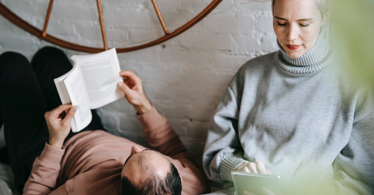 How to fix screen resolution in Minecraft Story Mode? - Unrecognizable man reading book while lying on comfortable bed with head on knees of concentrated wife surfing internet on tablet