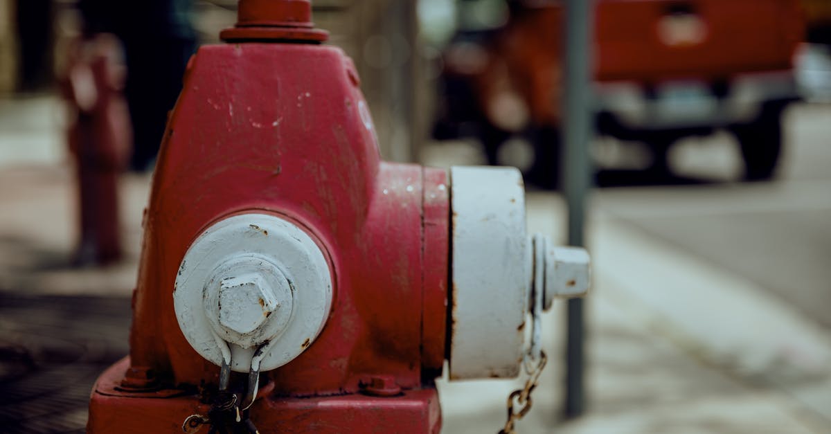 How to get Charmander as your Pokémon in Red Rescue Team? - Shabby red and white metal fire hydrant with rusty chain located on city street in daytime