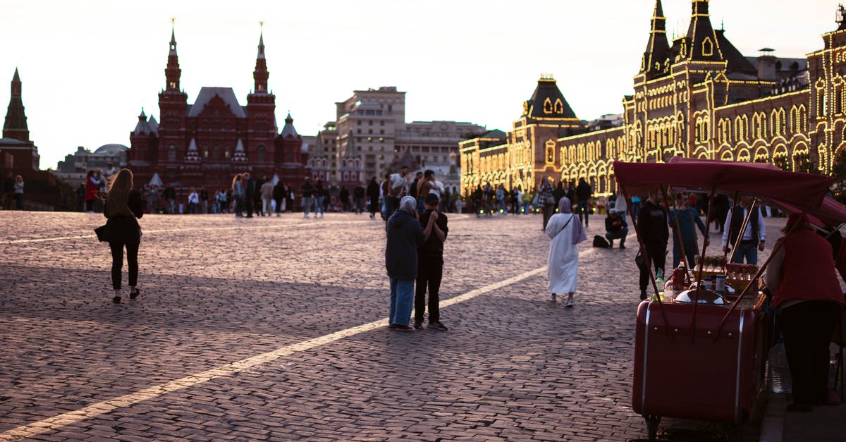 How to get into the castle with a drawbridge? - People Walking on Street Near Red Bus