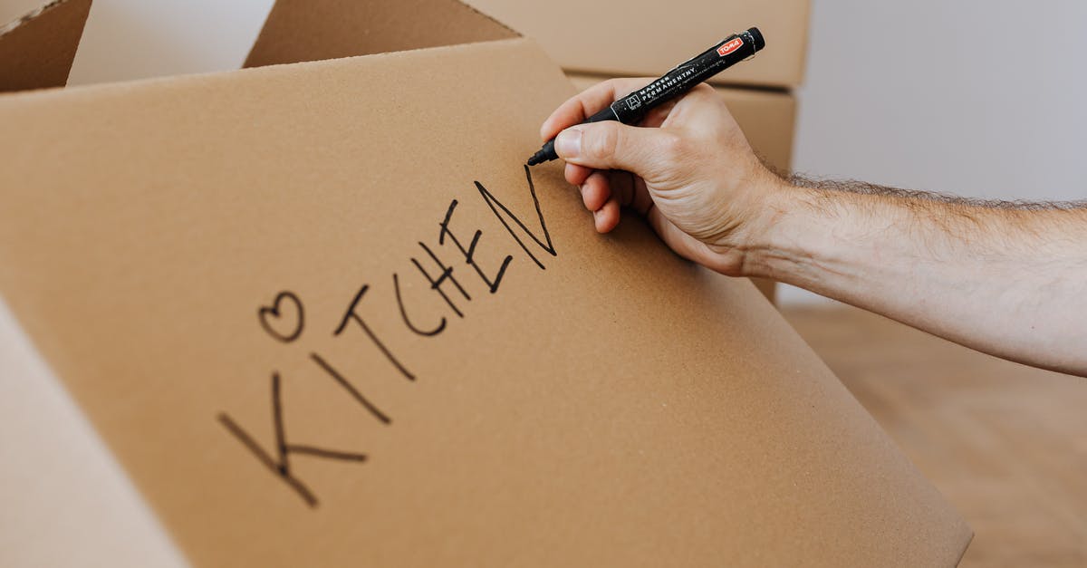 How to identify the base weapon? - Crop unrecognizable male using marker to write on carton box word kitchen and draw cute heart while packing kitchenware before relocation