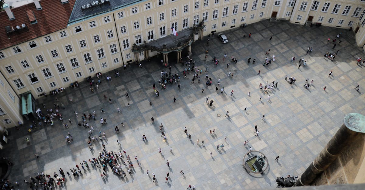 How to jump nose up while on your back - From above of travelers on square in front of aged vintage panoramic exploring sightseeing and studying place in daylight