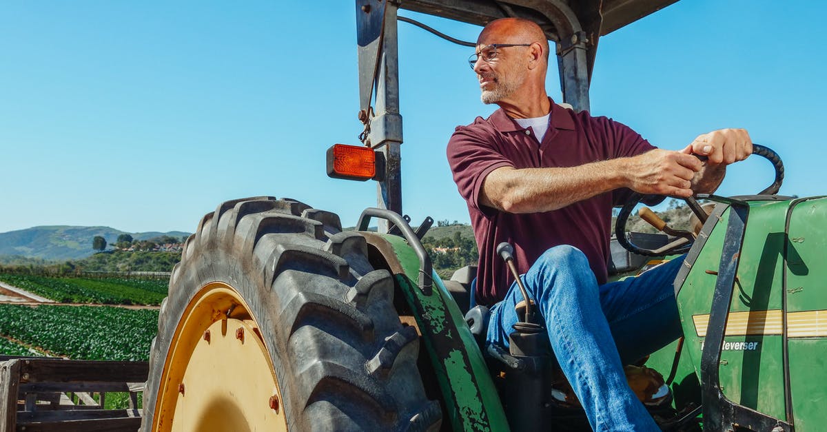 How to make an Iron farm in Minecraft survival? - Man in Brown and White Stripe Polo Shirt and Blue Denim Jeans Sitting on Green Tractor