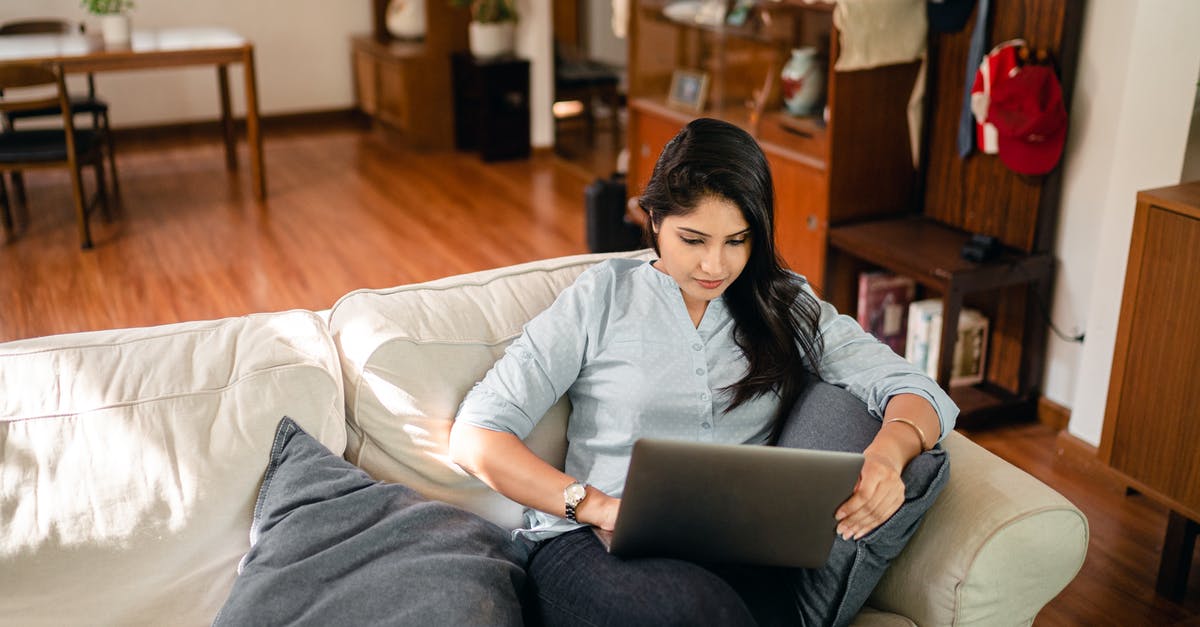 How to make FFXIV chat sticky from typing? - From above of young ethnic woman with long dark hair in casual clothes sitting on sofa and surfing internet on netbook while working remotely in cozy living room