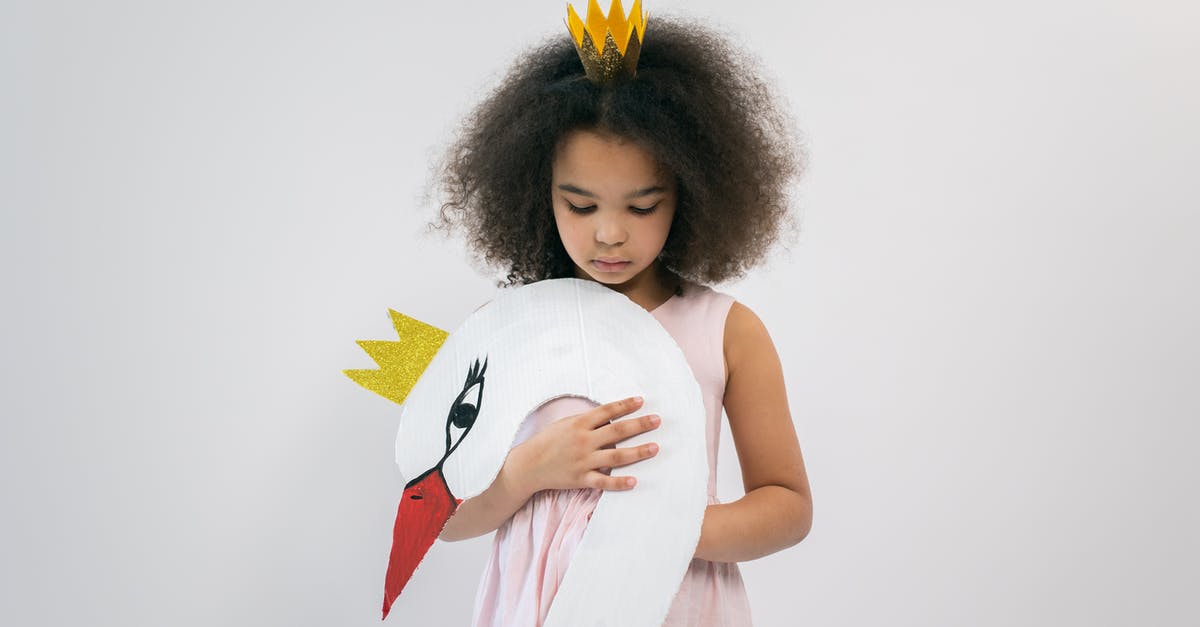 How to make Oleana appear in Crown Tundra? - Cute African American child in pink dress and crown holding paper swan with crown while looking down and standing on white background in studio