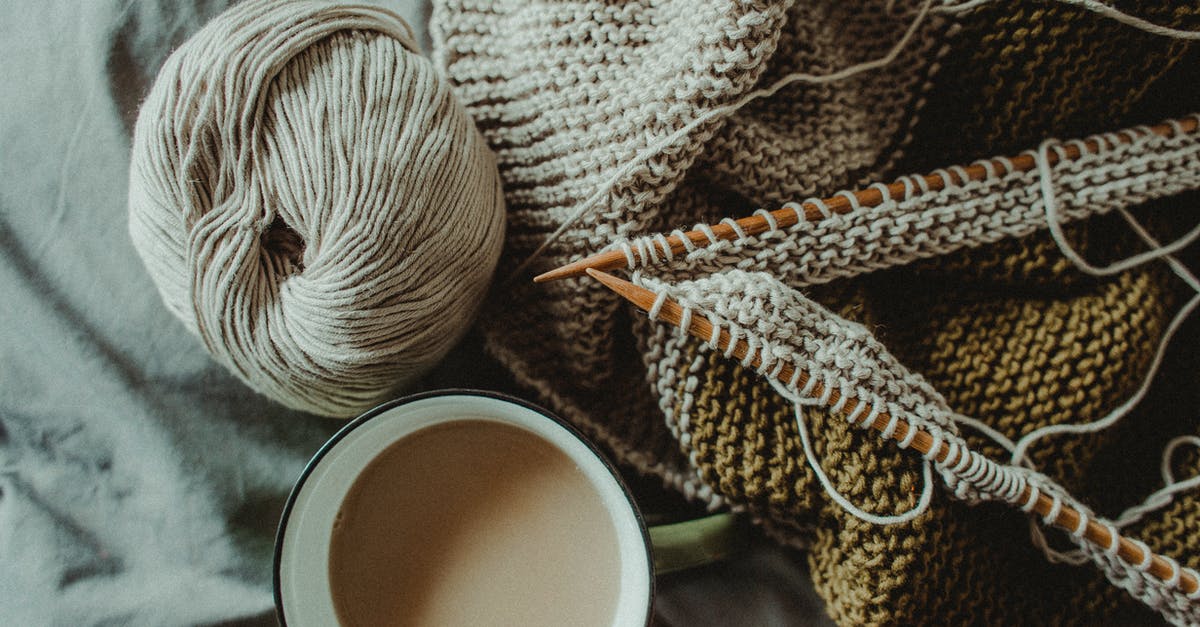 How to obtain or craft Pecha Scarf in Pokemon Dusk? - From above of cup of hot coffee placed on bed with handmade knitted plaid with needles and wool yarn