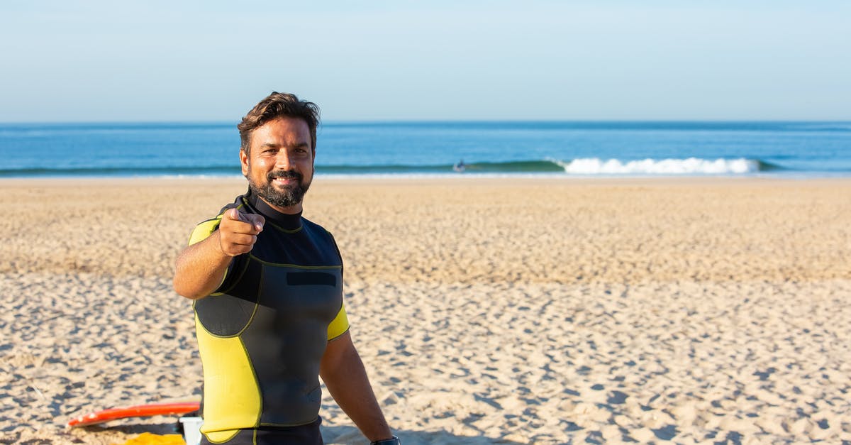 How to pick the HQ you want in skirmish mode? - Happy male in diving suit looking and pointing at camera while standing on beach in bright sunny day