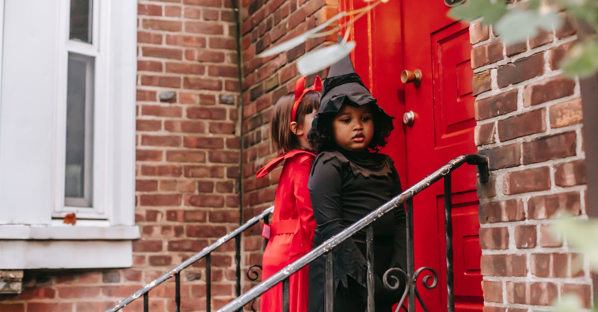 How to play custom NSMB levels on Wii? - Multiethnic kids dressed for Halloween celebrations standing near front door of red brick house playing trick or treat custom