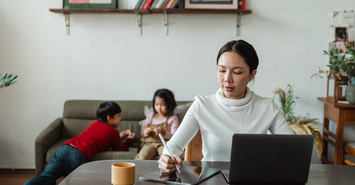 How to play Project M using a backup on USB? - Focused young Asian mother working remotely while children playing on sofa