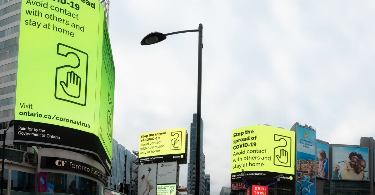 How to prevent others from changing a structure in Minecraft? - From below of modern buildings with billboards about coronavirus located on on city street under cloudy sky