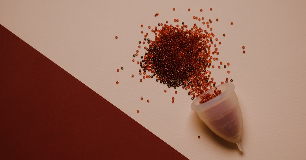 How to prevent overseas colonies from becoming vassals? - Top view of silicone menstrual cup with red beads scattered on pink surface